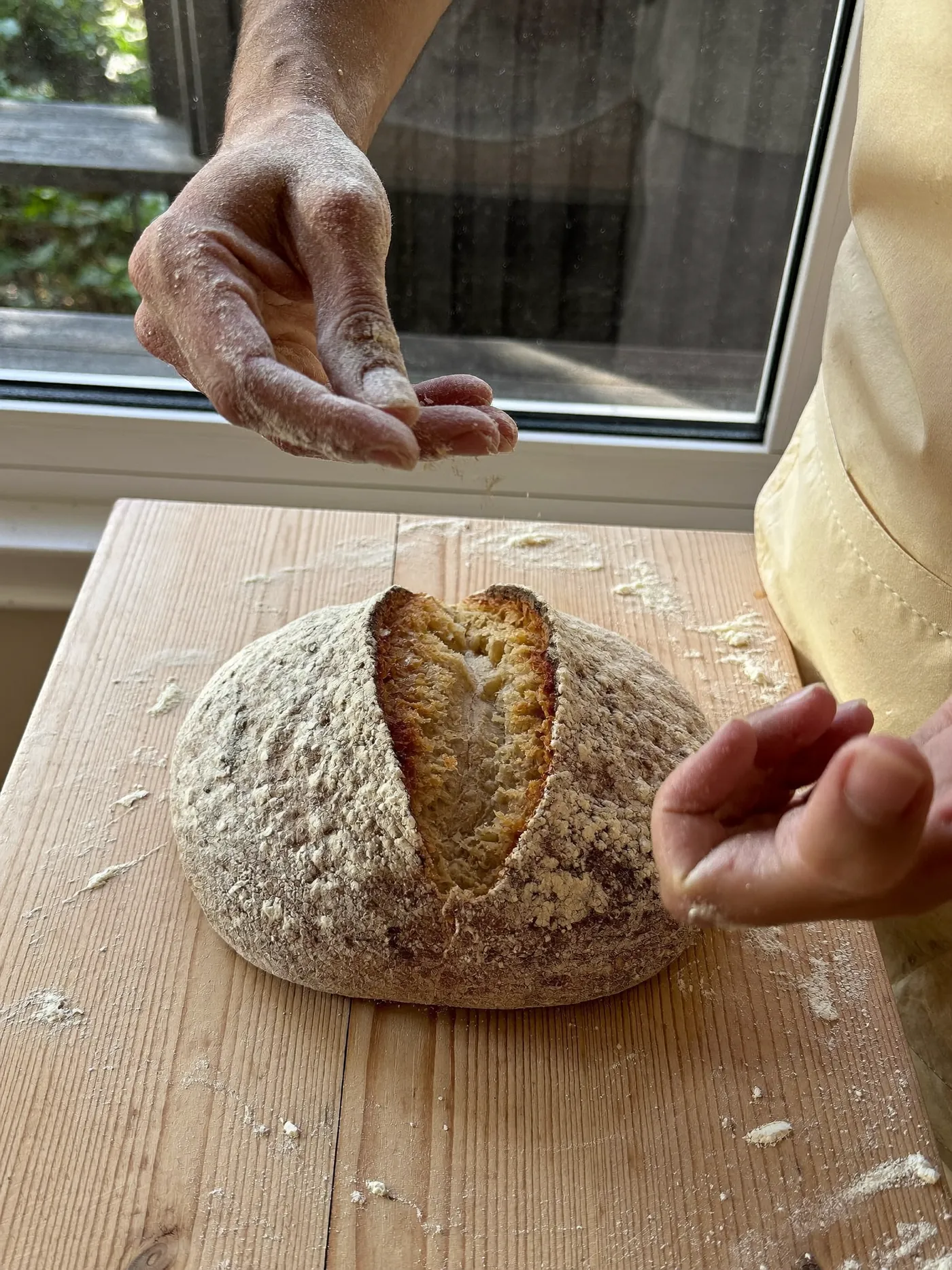 Mains farinées qui façonnent une boule de pâte